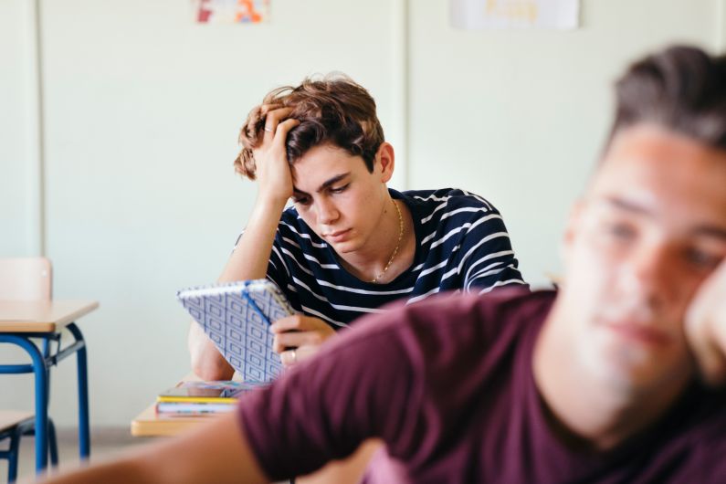 jovem em sala de aula olhando para sua agenda