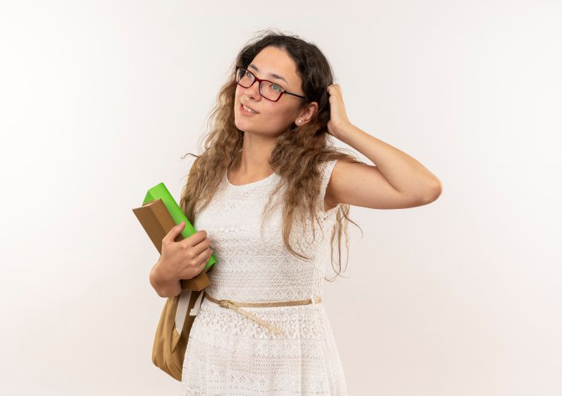 jovem pensativa de oculos e bolsa nas costas segurando livros colocando mao na cabeca