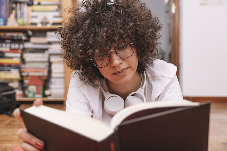 Adolescente, em, óculos, livro leitura, ligado, chão