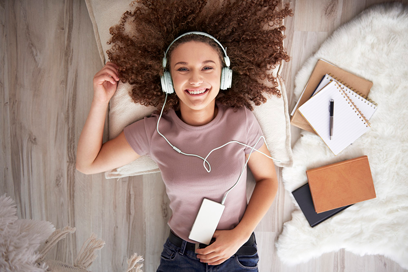 Retrato de uma adolescente sorridente ouvindo música